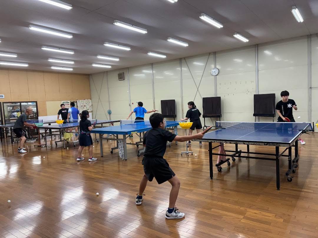 複数の選手が卓球台を囲んで練習する様子